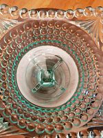Top-down view showing hobnail pattern on circular bowl surface and starburst pattern on square pedestal foot.