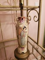 Photo showing the front view of the lamp base with the detailed painted woman in traditional East Asian clothing with floral patterns around her.