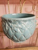 Front side view of the aqua glazed jardiniere showing quilted diamond texture and raised leaf and berry motifs on the rim.