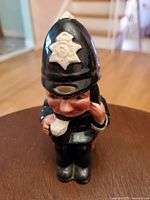 Front and side view of the vintage ceramic policeman milk jug showing detailed painting including helmet badge and facial features.