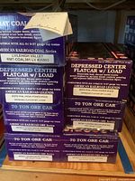 Overview of stacked American Railroad Legends train car boxes showing coal hopper, flatcars, and ore cars