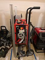 Overview of folded table saw on stand with accessories around