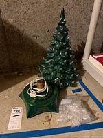 Photo showing the green ceramic Christmas tree with clear bulbs and the separate matching green ceramic base with electrical cord included.