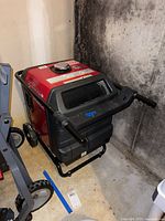 Front left three-quarter view showing overall generator, frame, wheels and handles