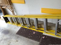 Full side view of the 8-foot yellow fiberglass ladder showing its length and construction.