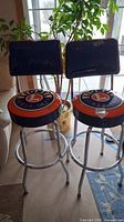 Front view of two matching Lionel vinyl and metal bar stools arranged side by side
