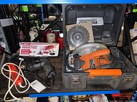 Ridgid R3200 circular saw inside carrying case with additional saw blade, plus VSR drill and Chicago Multifunction power tool boxed on table