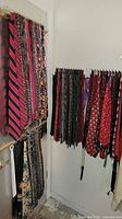 Men's ties hanging on racks, showing variety of patterns and colors including stripes, geometric, and novelty prints.