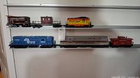 All six train models displayed on two shelves