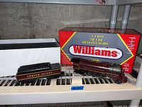 Locomotive and tender side view on shelf with Williams box behind