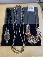 Photo showing all three necklaces displayed on a flat surface