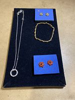 Full set with necklace, bracelet, and earrings on black display board