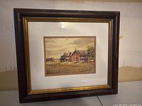 Framed farmyard print featuring a large brick farmhouse, under glass, in a dark brown wood frame with gold trim and white matte border. 14.5x13 inches.