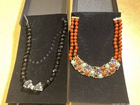 Photo of two Heidi Daus necklaces on black display, showing the full view of both necklaces side by side.