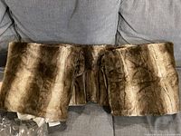 Folded brown faux fur throw blanket showing plush texture and natural pattern.