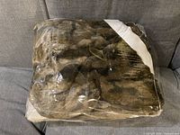 Foil-wrapped folded brown and black patterned faux fur throw blanket.