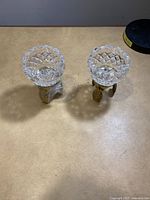 Pair of two 4 inch crystal votive holders with ornate cut crystal bowls and brass pineapple shaped bases.