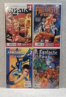 Four vintage Marvel comics displayed flat, including two issues of Fantastic Four and two of Fantastic Four 2099 with colorful illustrated covers.