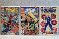 Photo of three The New Titans comic books in good condition arranged side by side.