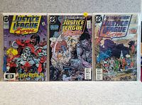 Photo of three Justice League comic books showing front covers.