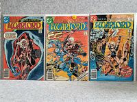 Photo showing three Warlord comic books side by side with visible colorful covers and titles