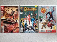 Photo showing three collectible comics: Ghost Ryder #1, Excalibur, and FF, all in good condition lying on a carpeted floor.