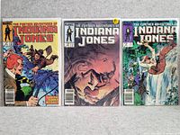 Photo showing three Marvel The Further Adventures of Indiana Jones comics laid flat, displaying the covers from left to right.