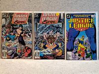 Photo showing three Justice League comic books laid side by side.