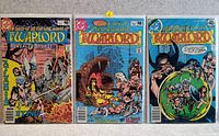 Photo of three Warlord comic books laid side by side showing their front covers