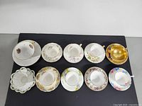 Top view of the 10 assorted porcelain cups and saucers laid in a row.