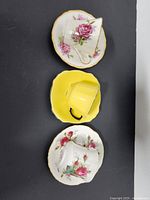 Top-down view of three cups and saucers showing floral and solid yellow designs