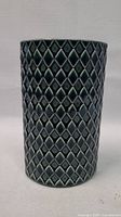 Front view of dark glossy textured vase with harlequin diamond pattern.