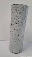 Full view of tall, cylindrical pottery vase with white textured glaze and black speckles.
