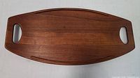 Full overhead view of the mid-century modern teak serving tray showing shape and cutout handles.