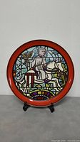 Full view of the Poole Pottery collectible medieval design plate with red rim and knight on horseback illustration.