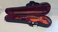 Violin with bow inside black soft case with burgundy lining, zipper closure visible