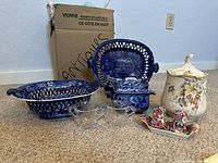 Overview of lot showing three blue pierced pieces, lidded dishes, floral salt & pepper set, and glass cream and sugar.