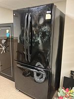 Full exterior front view of closed refrigerator doors and freezer drawer