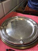 Large round silver-plated tray with three shell decorations on the rim, approximately 13 inches across