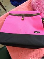 Bright pink and black zippered seat cushion or storage bag for car use