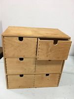 Front view of wooden multi-drawer cabinet showing 6 drawers with half-circle cutouts for handles.