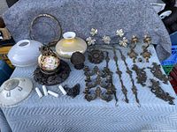 Overview of all items including ornate cast metal fixtures, ceramic painted globe, and various glass lamp shades.