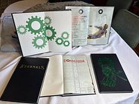 Front cover designs and four Ex Machina books fanned out with Eternals book in front on cloth surface.