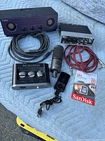 Lot contents showing Yamaha speaker, M-Audio interface, dynamic microphone, cables, and SanDisk memory card