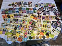 Full spread of Pokemon cards and Pog Slammers laid out on a table, showcasing variety of cards and tokens.