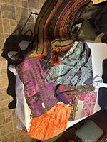 Photo of a multicolored silk and fabric tablecloth with patchwork patterns, fringed edges, and vibrant colors