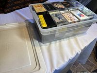 Plastic tub filled with cassette tapes with some tape cases visible on top showing a mix of different titles and labels.