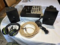 Photo of the entire lot: pair of Yamaha NS-AW1 speakers, Numark DM1050 mixer, Turtle Beach headphones, patch cord, and power adapter on a table