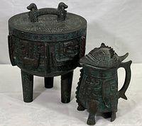 Front and side view of metal ice bucket and water pitcher showing detailed Aztec motifs and overall design