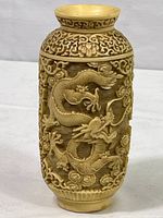 Front and side view of carved Chinese dragon vase with relief dragon detail and floral scroll work.